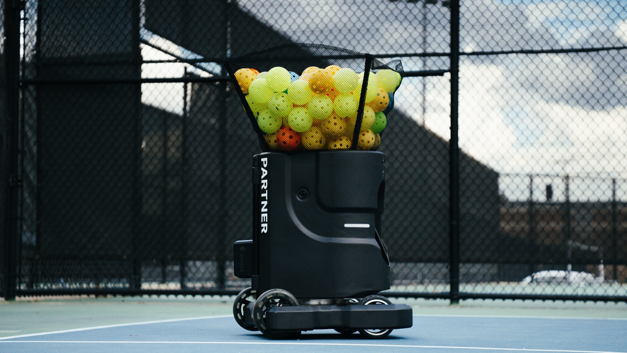 Tennibot Partner V2 pickleball machine loaded with pickleballs on an outdoor court